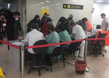 Pasagerii veniți în România din Regatul Unit, înainte de intrarea în vigoare a suspendării zborurilor, stau la coadă la triaj pe aeroport, fără respectarea distanțării fizice - Foto: Digi24